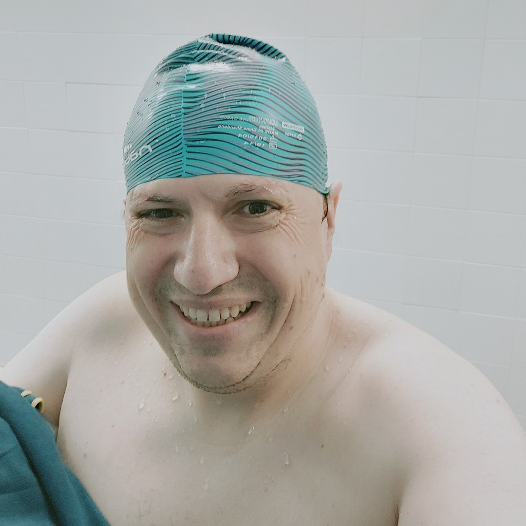 Hombre gordo con gorro azul de piscina